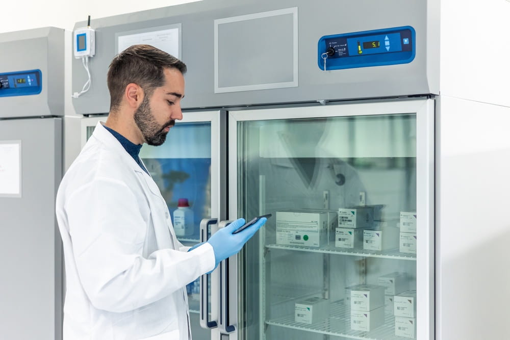 doctor monitoring refrigeration temperature with IoT medical device